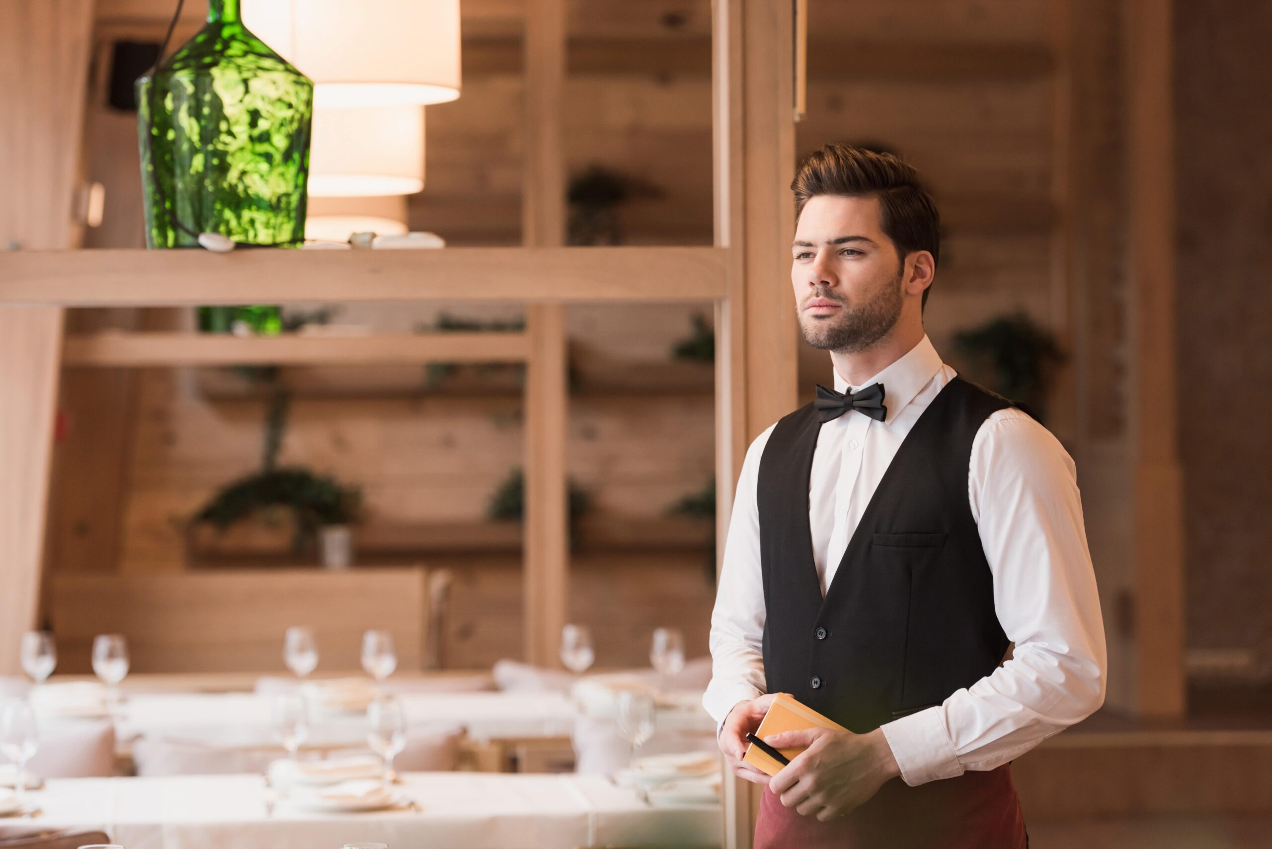 waiter standing with notebook and pen and looking 2024 11 17 12 44 47 utc min